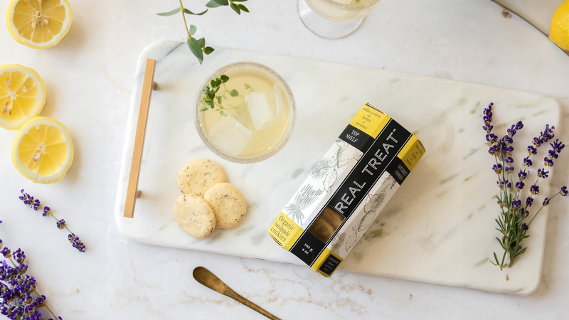 Real Treat Top Shelf Organic Lemon Sables cookies on a marble board with lavender and fresh lemons. 