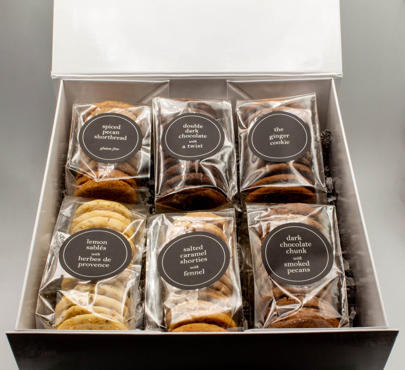 A shiny white gift box contains six bags of gourmet organic cookies by Real Treat.